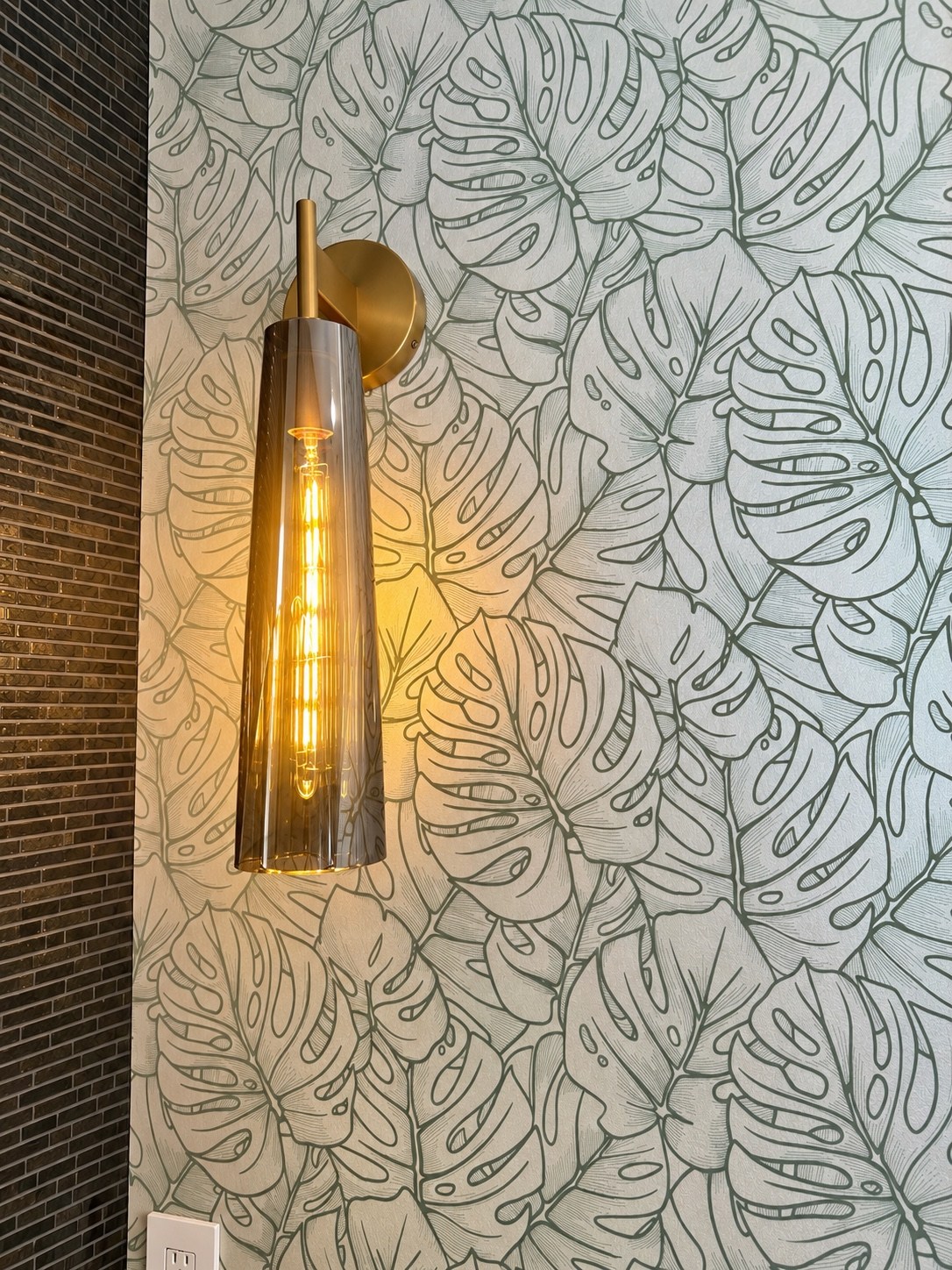 Powder room botanical wall pattern and brass sconce