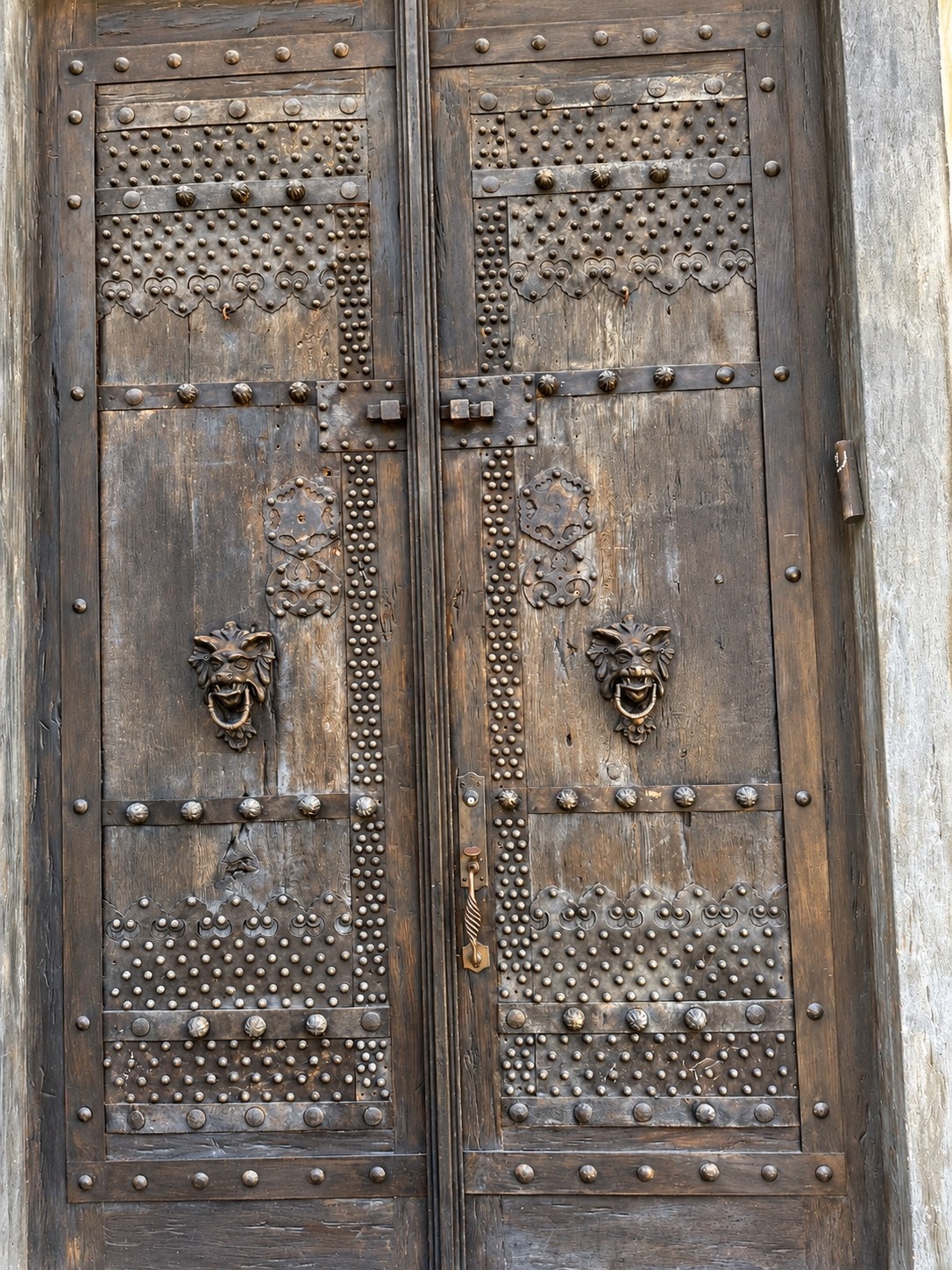 Wood entrance doors with studded metal detailing