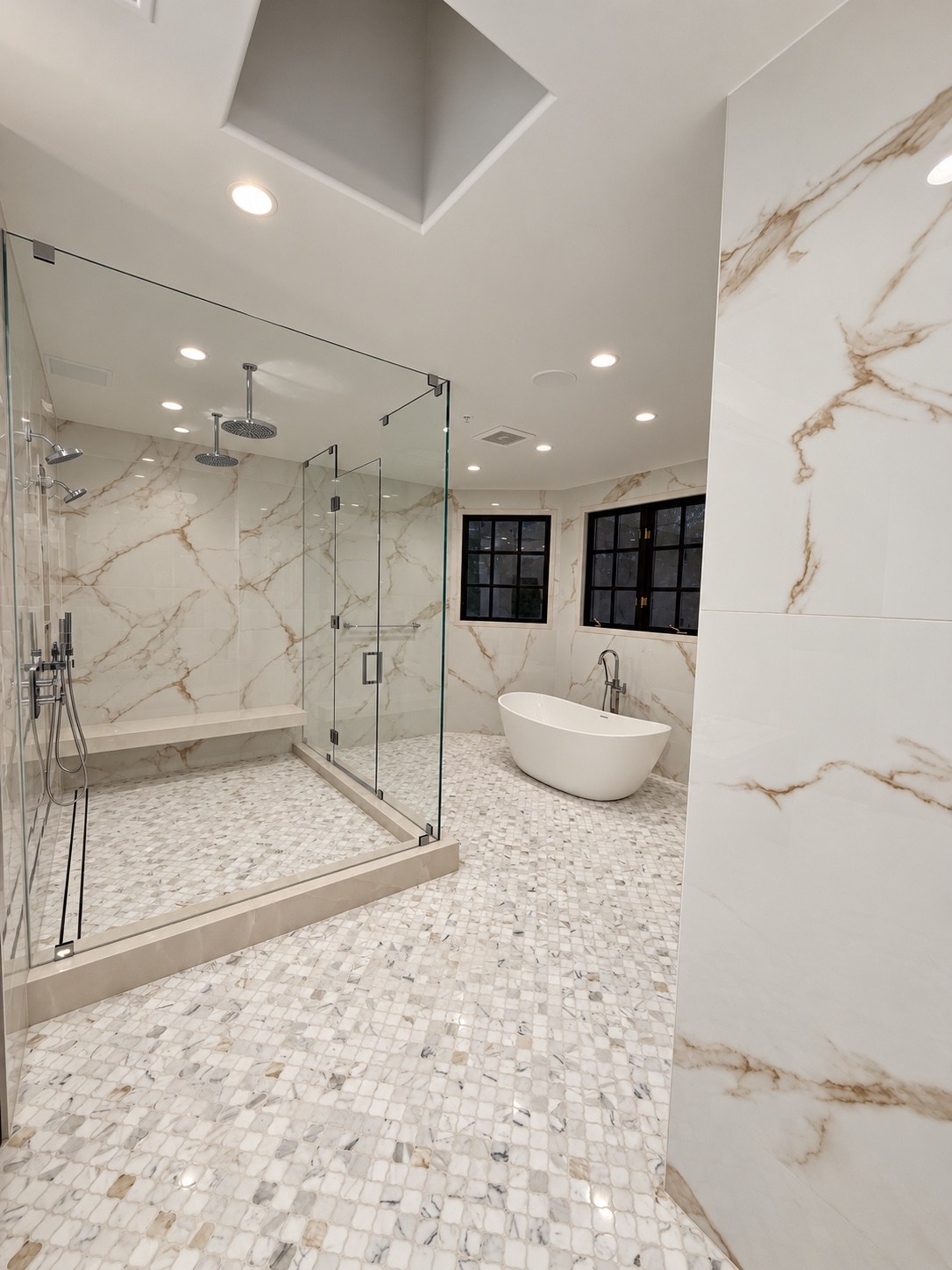 Walk-in shower and freestanding tub with warm veined stone walls