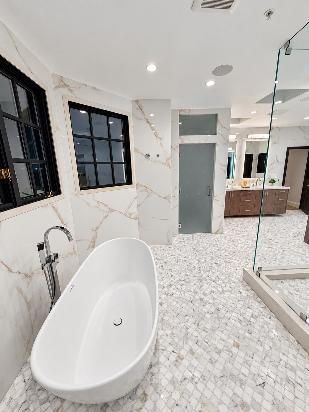 Freestanding tub and wood vanity in the stone bathroom