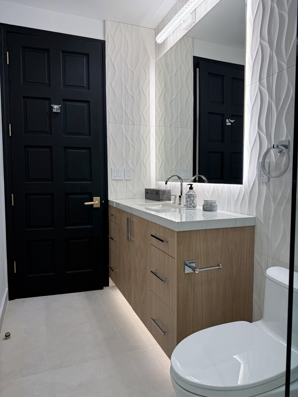 Bathroom with wood vanity and illuminated mirror